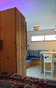 Tiny home Texel في دن بورخ: غرفة معيشة مع طاولة وأريكة