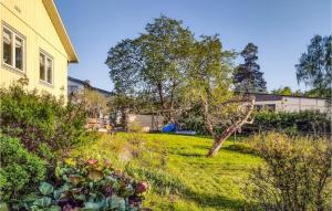 a yard with a yellow house and some plants at Stunning Home In Tby With Kitchen in Täby