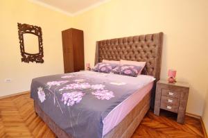 a bedroom with a large bed with purple sheets and a mirror at Apartment Anima in Tivat