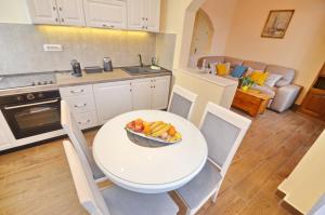 a kitchen with a table with a bowl of fruit on it at Apartment Anima in Tivat