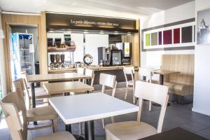 a restaurant with tables and chairs and a counter at Hôtel Inn Design Vierzon in Vierzon
