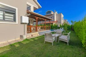 a patio with chairs and a table in a yard at Near By THE LAND OF LEGENDS , VİLLA PARADİSE in Belek