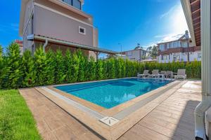 - une piscine dans l'arrière-cour d'une maison dans l'établissement Near By THE LAND OF LEGENDS , VİLLA PARADİSE, à Belek