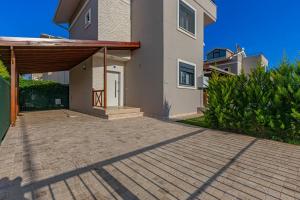 a house with a large patio in front of it at Near By THE LAND OF LEGENDS , VİLLA PARADİSE in Belek