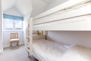 a bedroom with a bunk bed and a chair at Rock Lobster in Port Isaac