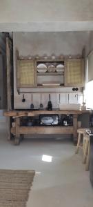 eine Küche mit einem Tisch und Tellern auf den Regalen in der Unterkunft ClockWise Earthy Vibe House in Apano Chora in Ano Syros