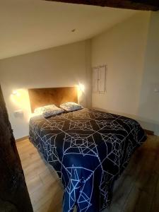 Schlafzimmer mit einem Bett mit einer blauen und weißen Bettdecke in der Unterkunft Apartamento Moises in Santander