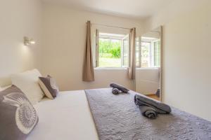 a bedroom with a white bed and a mirror at Bepo Apartments at beach in Metajna