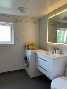 a bathroom with a washing machine and a sink at Huset i hagen in Mandal