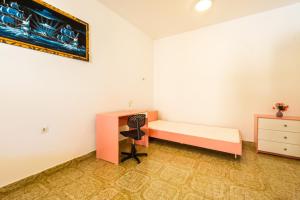 a bedroom with a desk and a bed and a dresser at Bepo Apartments at beach in Metajna