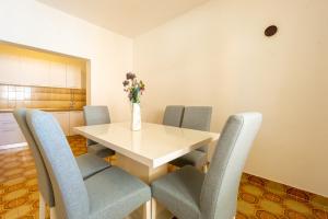 a dining room table with chairs and a vase of flowers at Bepo Apartments at beach in Metajna