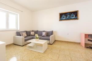 a living room with a couch and a table at Bepo Apartments at beach in Metajna