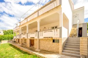 an exterior view of a white building with stairs at Bepo Apartments at beach in Metajna