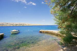a boat sitting in the water next to a beach at Bepo Apartments at beach in Metajna