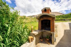 an outdoor brick oven in the middle of a field at Bepo Apartments at beach in Metajna