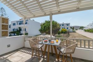 a patio with a table and chairs on a balcony at Orama Suites Milos in Adamas