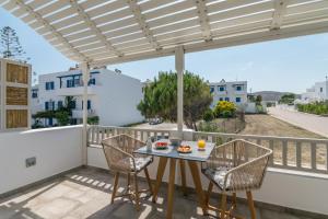 un patio con tavolo e sedie su un balcone di Orama Suites Milos ad Adámas