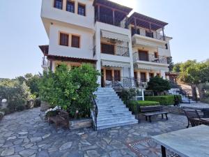 ein Gebäude mit Treppe und Tischen davor in der Unterkunft Platanias Hillside in Platanias