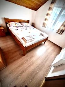 Ce lit se trouve dans un dortoir doté de parquet. dans l'établissement Casa Andrei, à Eşelniţa