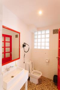 La salle de bains est pourvue de toilettes, d'un lavabo et d'un miroir. dans l'établissement Le Cocooning 974 Hôtel Restaurant Réunion, à Antananarivo