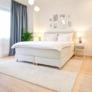 een slaapkamer met een groot wit bed en een tapijt bij Urban Apartments in Brno