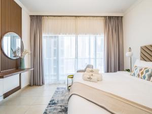 um quarto com uma cama grande e uma janela grande em Delightful Studio with Balcony - Burj Al Nujoom em Dubai
