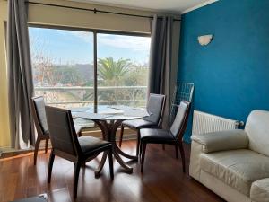 a living room with a table and chairs and a couch at Departamento Holiday Park Reñaca 306 Familiar in Viña del Mar