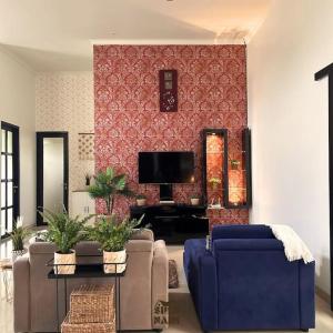 Villa Siku Naim, Sukabumi في سوكابومي: غرفة معيشة مع أريكة وتلفزيون