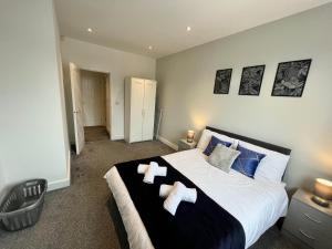 a bedroom with a large bed with two teddy bears on it at Modern Serviced Apartment - Near City Centre in Doncaster