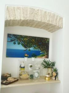 a shelf with a painting on a wall with plants at ACANTHUS in Terlizzi +24 photos