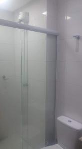 La salle de bains est pourvue d'une douche en verre et de toilettes. dans l'établissement Everest Flat, à Caldas Novas