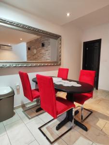 a dining room with a black table and red chairs at Sea star Apartment in Tivat