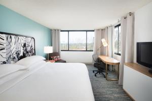 a hotel room with a bed and a desk and a television at Sheraton Miami Airport Hotel and Executive Meeting Center in Miami