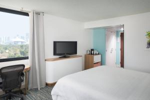 a hotel room with a bed and a desk and a television at Sheraton Miami Airport Hotel and Executive Meeting Center in Miami