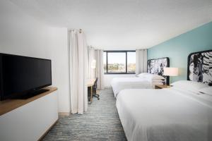 a hotel room with two beds and a flat screen tv at Sheraton Miami Airport Hotel and Executive Meeting Center in Miami