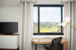 a room with a desk and a television and a window at Sheraton Miami Airport Hotel and Executive Meeting Center in Miami