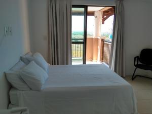 ein Schlafzimmer mit einem weißen Bett und einem Balkon in der Unterkunft Cobertura Duplex Beverly Hills in Aquiraz + 41 Fotos