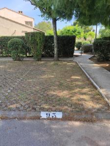 a white sign on the ground in a yard at AGRÉABLE STUDIO cabine PROCHE MER in La Londe-les-Maures