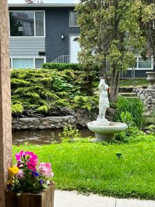 a statue of a woman sitting on a fountain in a garden at Kelowna little Island 3 units near Downtown, lake, hospital and Okanagan Collage in Kelowna