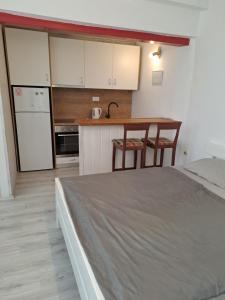 a bedroom with a bed and a kitchen with a table at Apartmani Katarina in Biograd na Moru