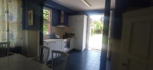 een keuken met blauwe muren en een tafel en een raam bij CABANAS 1ª LINEA PLAYA in Cabañas
