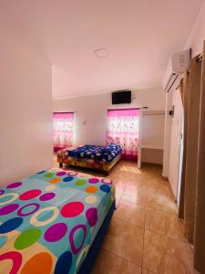 a bedroom with two beds and a flat screen tv at Casa de Huéspedes Playas Arena in Playas