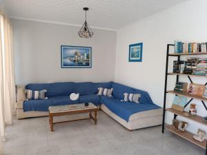 a living room with a blue couch and a table at Mina Studios in Kardamaina