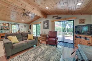 un soggiorno con divano e TV di Rose City Cabin with Fire Pit and Lake Access 
