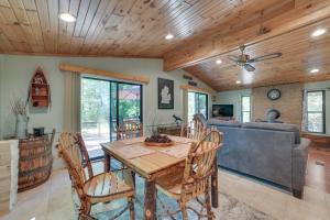 comedor con mesa y sofá en Rose City Cabin with Fire Pit and Lake Access, 