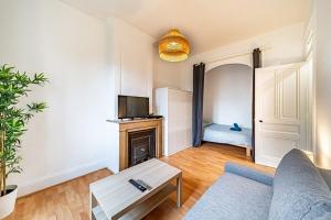 uma sala de estar com um sofá e uma lareira em Chez Florence- cosy 2 pers-métro Grange Blanche em Lyon