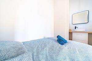 um bicho de peluche azul sentado em cima de uma cama em Chez Florence- cosy 2 pers-métro Grange Blanche em Lyon