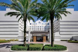 zwei Palmen vor einem Gebäude in der Unterkunft Sheraton Suites Fort Lauderdale Plantation in Plantation