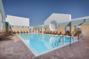 ein großer Pool in einem Hotel mit Stühlen in der Unterkunft Sheraton Suites Fort Lauderdale Plantation in Plantation