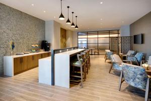 a bar in a restaurant with chairs and a bar counter at Sheraton Suites Fort Lauderdale Plantation in Plantation